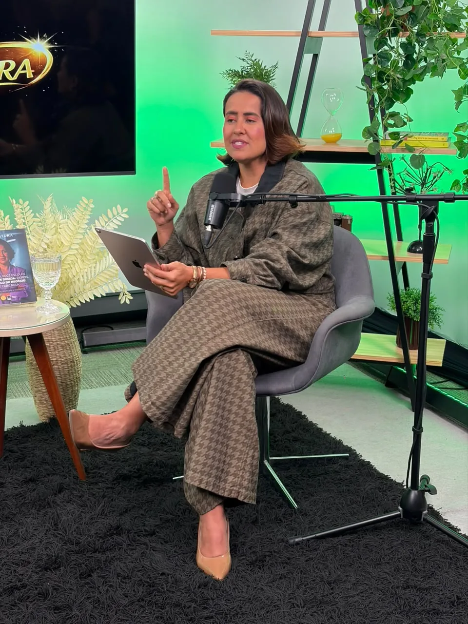 Apresentadora gravando em pé no fundo verde